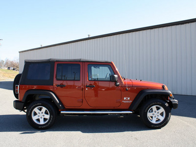 jeep wrangler unlimited 2009 orange suv x gasoline 6 cylinders 4 wheel drive automatic 27215